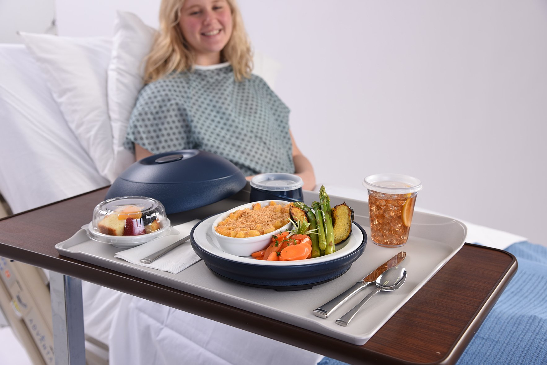 Photo of a patient smiling at their meal which has been delivered with Aladdin Tray Pod Service