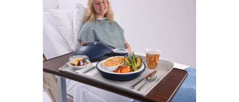 Photo of a patient smiling at their meal which has been delivered with Aladdin Tray Pod Service